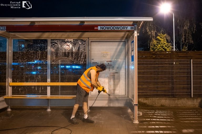 Pracownik nocą myje wiatę myjką ciśnieniową Fot. Zarząd Oczyszczania Miasta