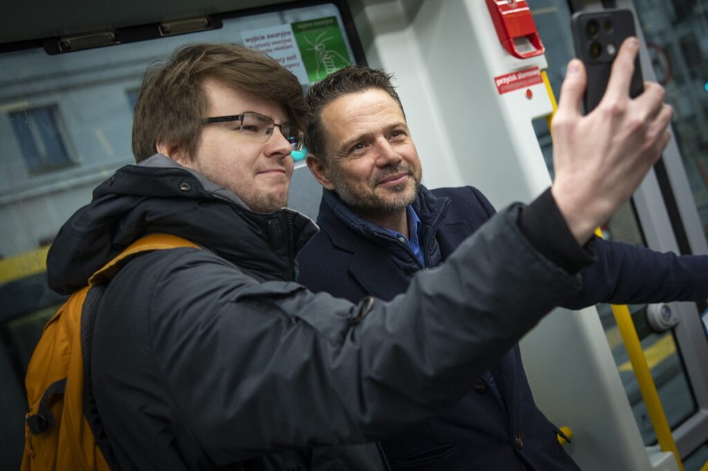 Prezydent Rafał Trzaskowski robi sobie selfie z pasażerem