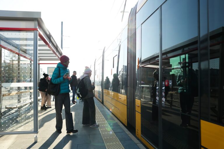 Pasażerowie na przystanku, wsiadający do tramwaju